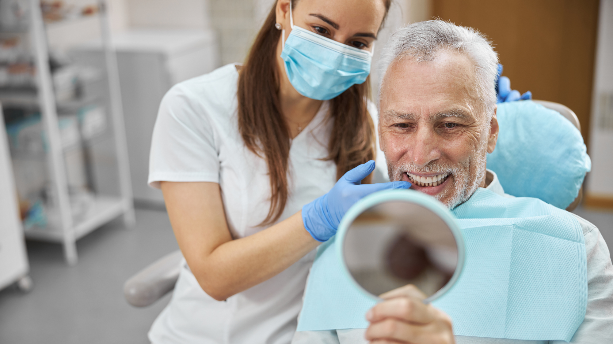 En pasient smiler fornøyd etter å ha fått nye tenner med behandling hos Eiksmarka Tannlegesenter